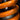 Close-up of the dual adjustment shock spring on the Begode Extreme Ibex Electric Unicycle, showcasing its vibrant orange color.
