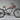 Cheetah Plus Cafe' Racer Ebike with BAFANG motor, brown seat, and mountain tires on a gray background.