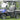 TrailMaster Taurus 50EV 4-seat electric golf cart on grass with DOT light package, aluminum wheels, and off-road tires