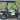 TrailMaster Taurus 50EV 4-seat electric golf cart with 60V motor, off-road tires, and DOT light package in a park setting.