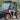 Red TrailMaster Taurus 50EV 4-Seat Electric Golf Cart with DOT lights, aluminum wheels, and off-road tires in park setting.