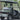 TrailMaster Taurus 50EV 4-Seat Golf Cart with aluminum wheels and off-road tires, featuring DOT light package, parked on road.