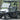 TrailMaster Taurus 50EV 4-seat electric golf cart with DOT light package, aluminum wheels, and off-road tires on a road.