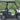 TrailMaster Taurus 50EV electric golf cart with 60V motor, aluminum wheels, and off-road tires, parked on a scenic road.