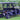 TrailMaster Taurus 80ED 4-Seat Electric Golf Cart with dump bed and aluminum alloy wheels, parked on grass with trees in the background.