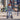 Young woman in a gray blazer riding a Hiboy VE1 Pro Electric Scooter on an urban street.