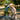Two children playing with electric scooters outdoors, wearing helmets and protective gear, enjoying a sunny day.