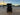 Rear view of TrailMaster TBM X6 6-seater electric golf cart with foldable windshield at sunset in an industrial area.