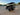 TrailMaster TBM X6 6-seater electric golf cart with foldable windshield and 22-inch rims, parked on a concrete surface at sunset.
