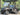 TrailMaster Taurus 50EV 4-Seat Electric Golf Cart with 60V motor, aluminum wheels, and DOT light package on paved road.