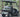 TrailMaster Taurus 50EV 4-Seat Golf Cart with aluminum wheels and off-road tires, featuring DOT light package, parked on road.