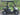 TrailMaster Taurus 50EV electric golf cart with 60V motor, aluminum wheels, and off-road tires, parked on a scenic road.